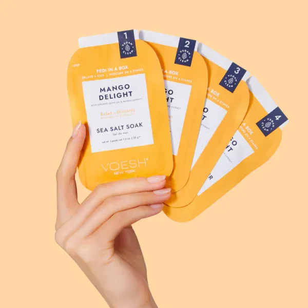 Set de cuatro paquetes de VOESH Pedi Moments Mango Delight en mano.